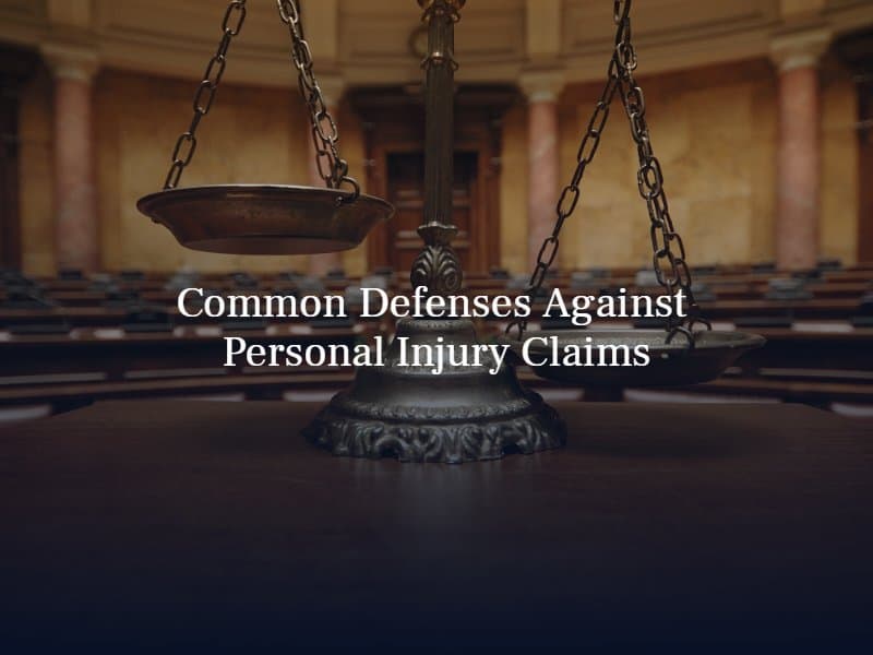 legal scale in an empty courtroom. Text: "Common Defenses Against Personal Injury Claims"